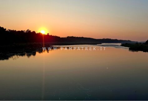 Tramonto sul fiume con il sole che illumina l'acqua